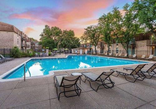 Outdoor pool with lounge chairs and umbrellas at Westgate Arms apartments for rent